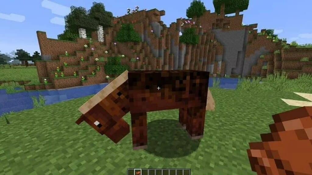 Caballo y silla de montar en la mano del jugador en Minecraft.